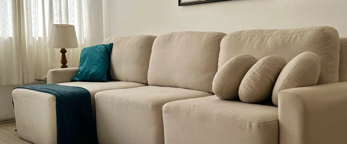 O sofá montado na sala, com o tapete e o quadro ao fundo